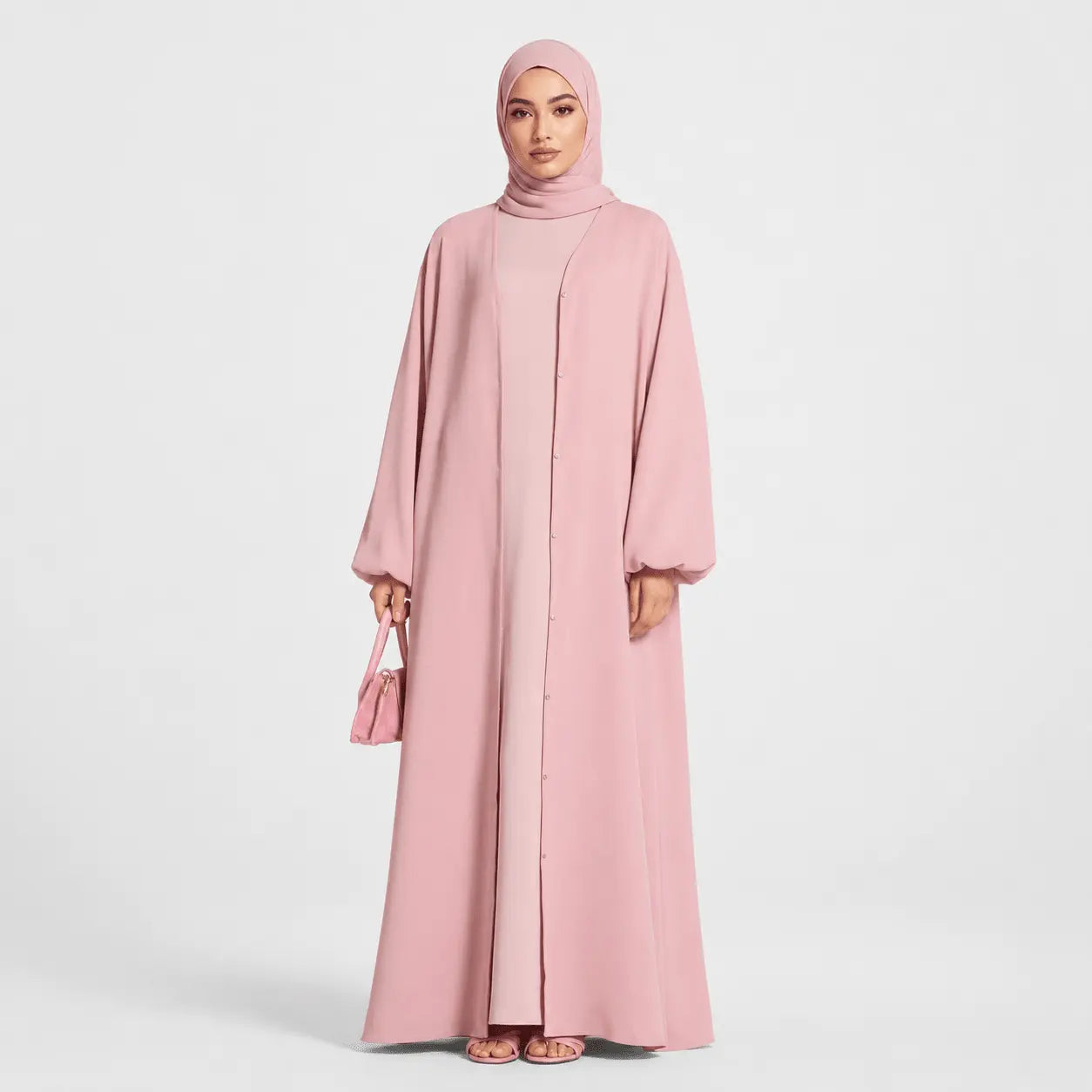 Woman wearing a pink abaya and hijab on a white background