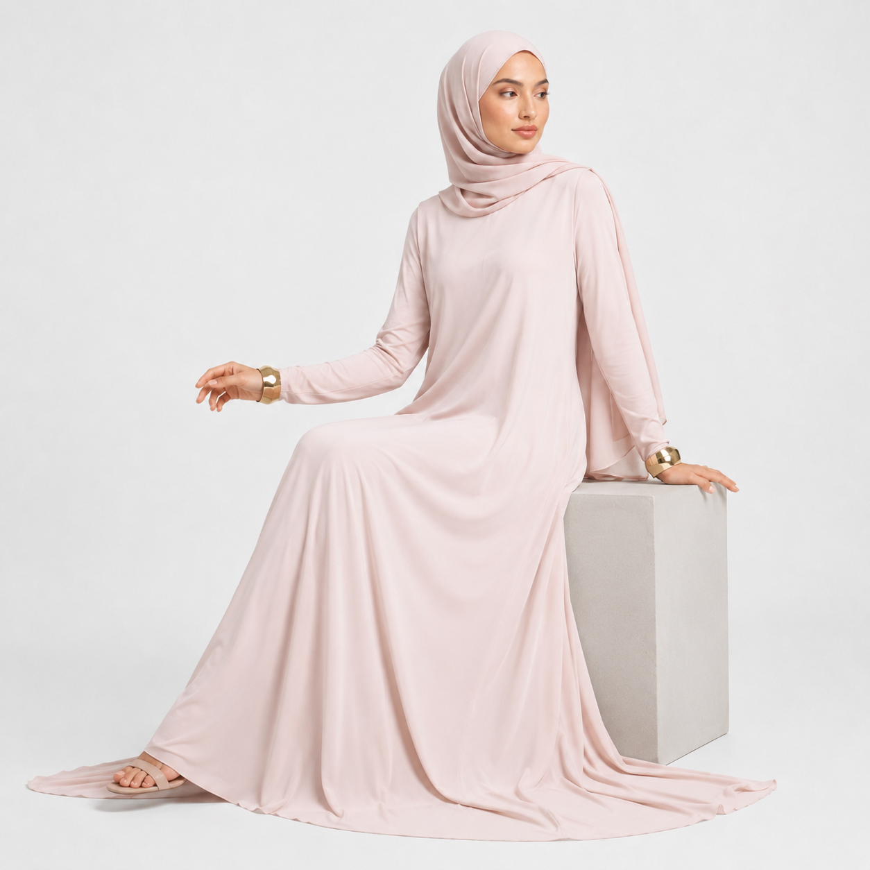 Woman wearing a light pink abaya on a white background