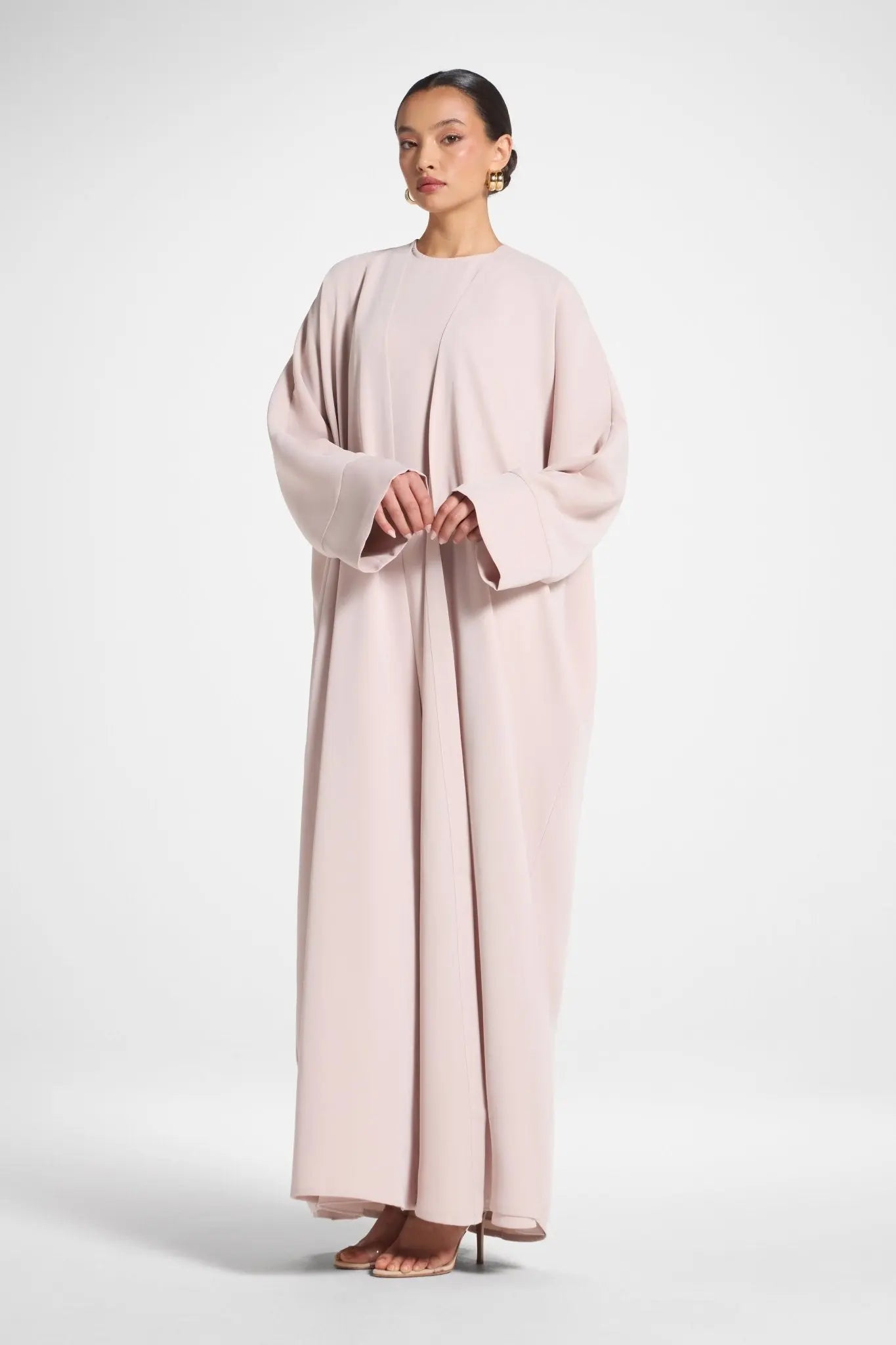 Woman wearing a light pink dress against a white background