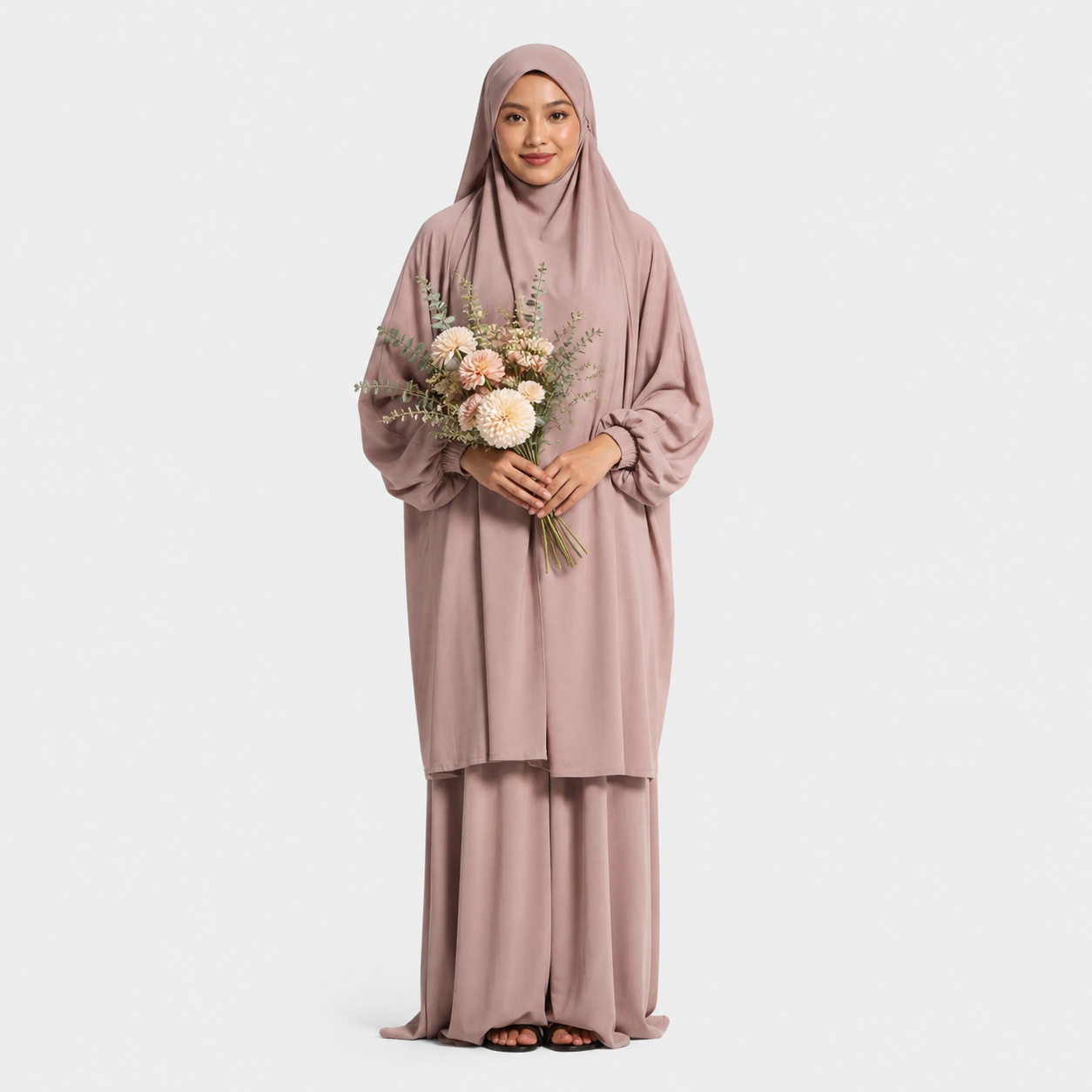 Woman in a pink traditional outfit holding flowers on a white background