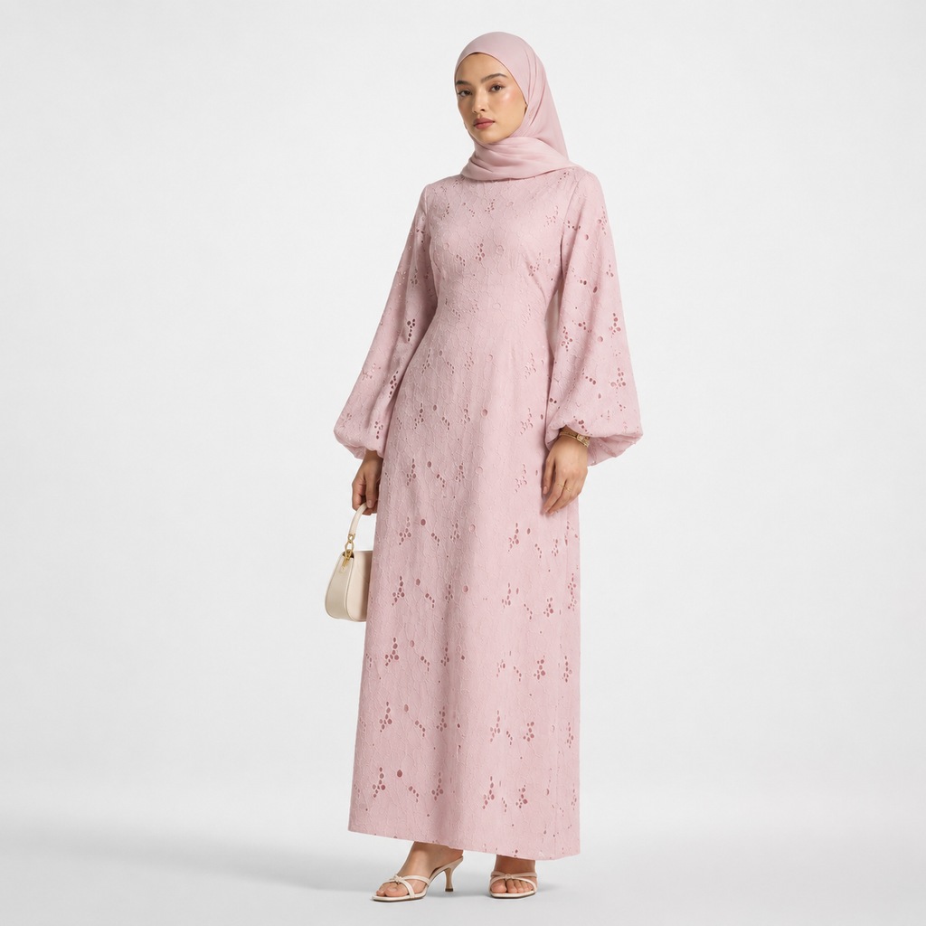 Woman wearing a pink dress with floral patterns on a white background