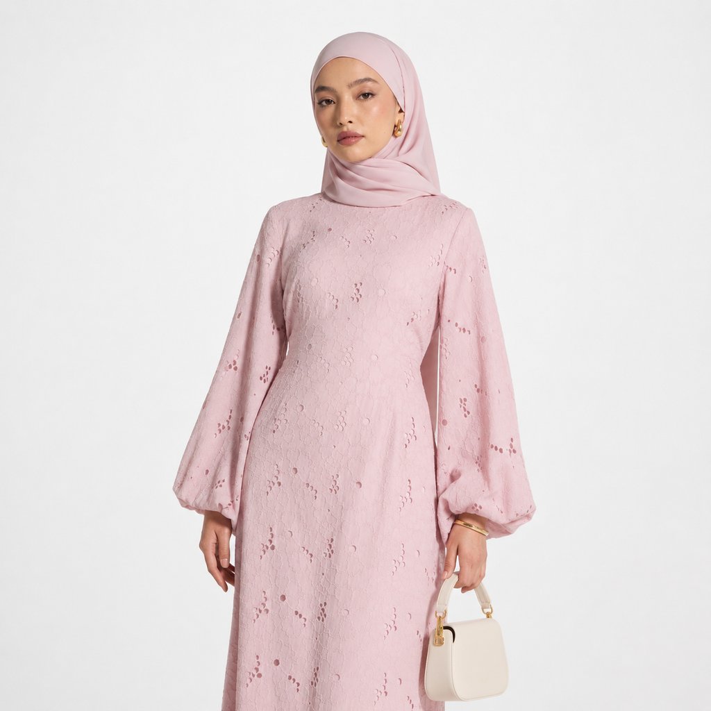 Woman wearing a pink floral dress and hijab on a white background