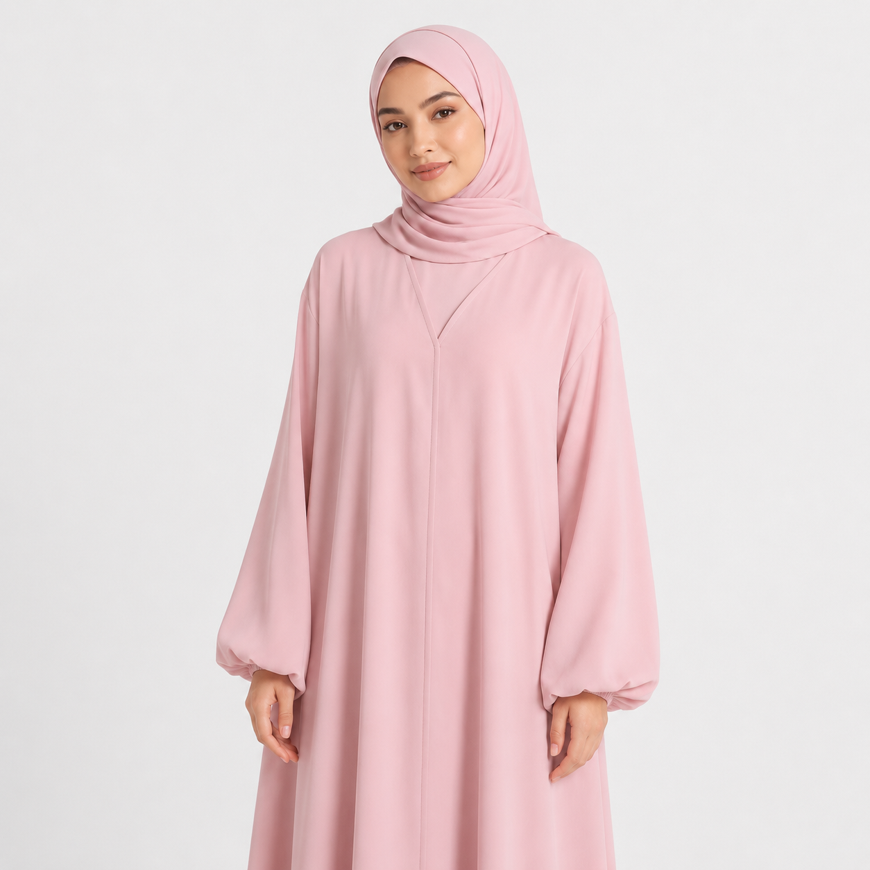 Woman wearing a pink abaya and hijab on a white background