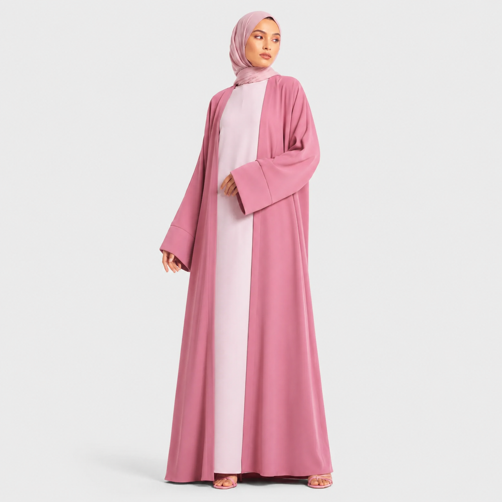 Woman wearing a pink abaya and hijab on a white background