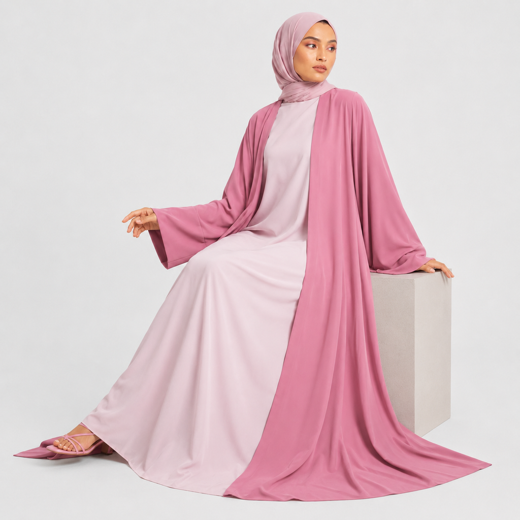 Woman wearing a pink abaya and hijab on a white background