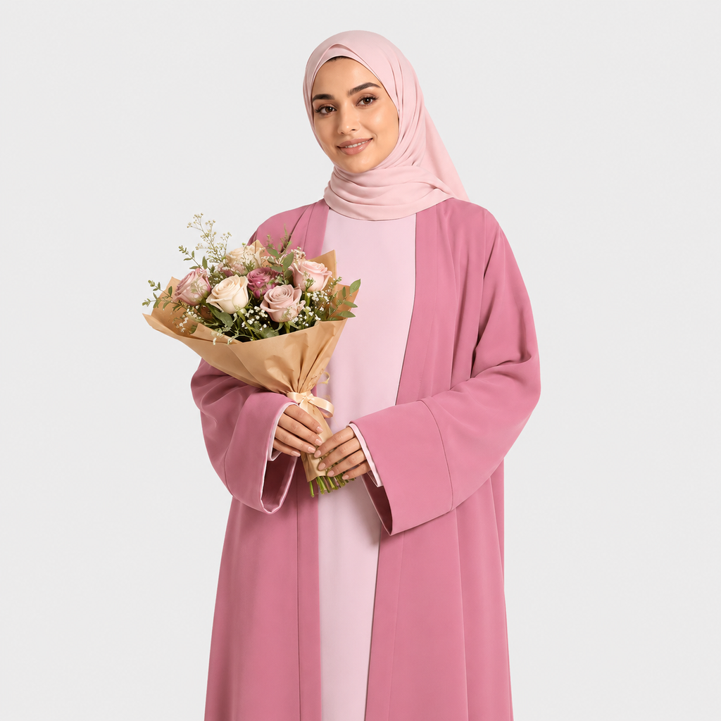 Woman in a pink outfit holding a bouquet of flowers on a light gray background