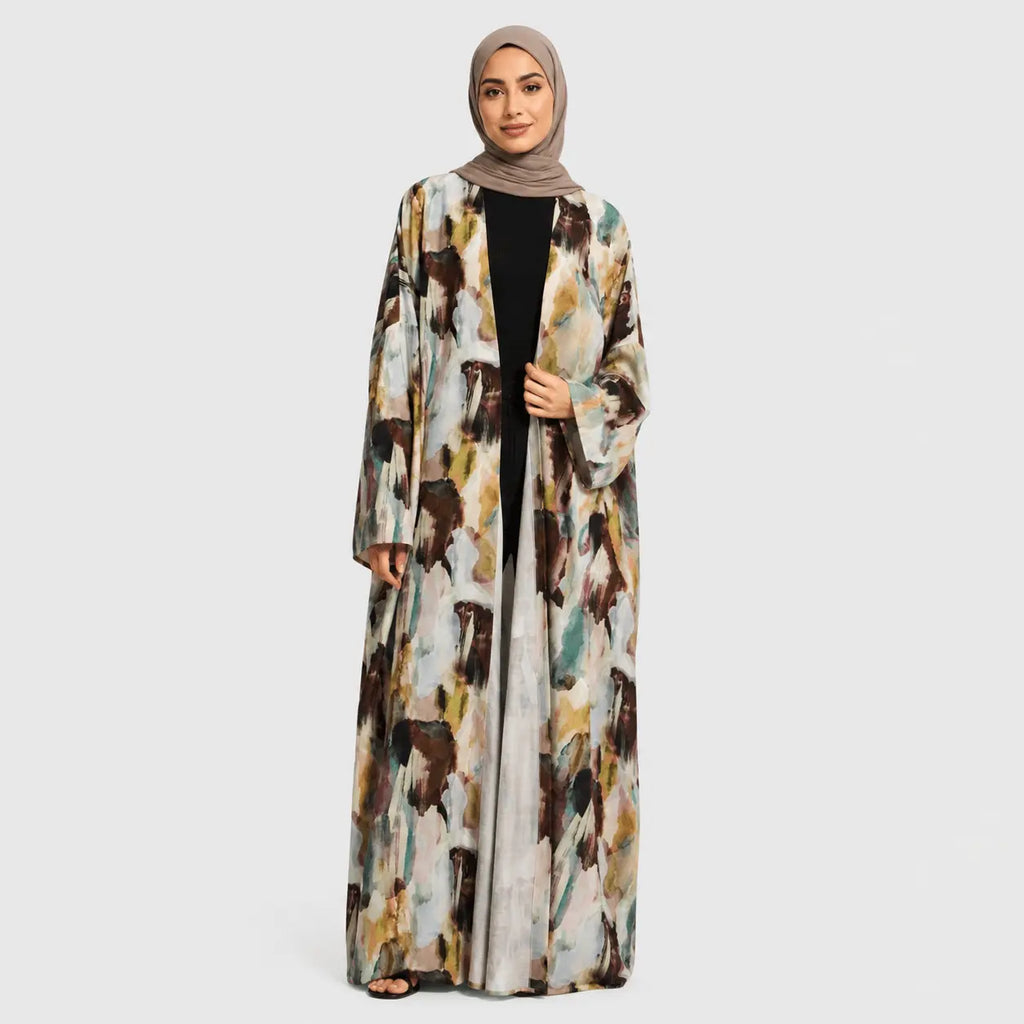 Woman wearing a long, patterned abaya on a white background
