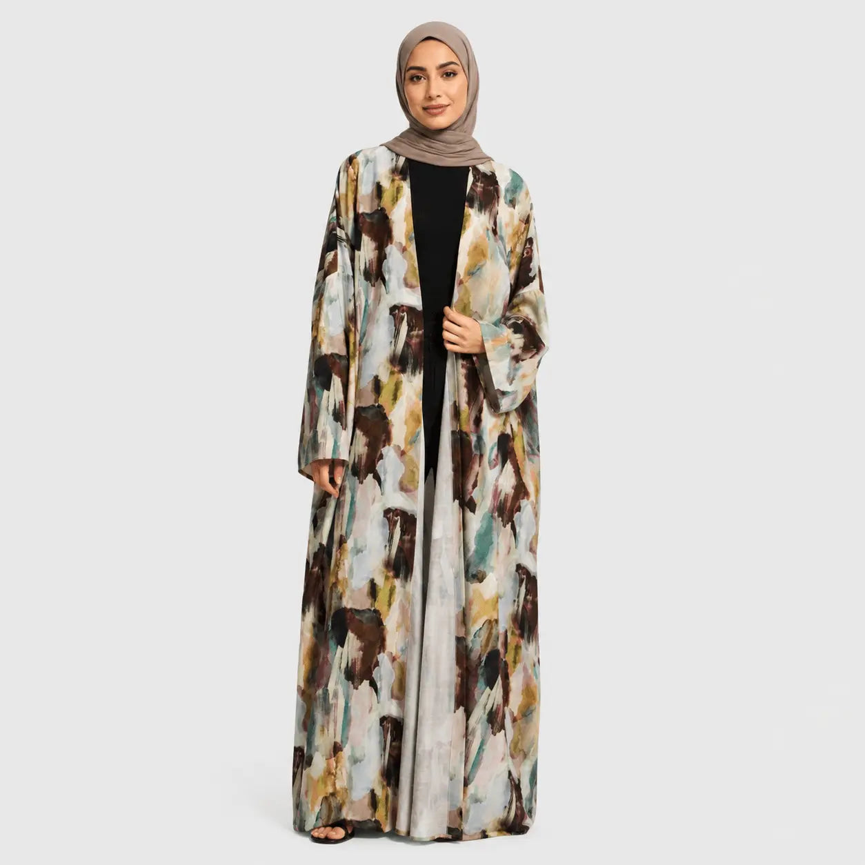 Woman wearing a long, patterned abaya on a white background