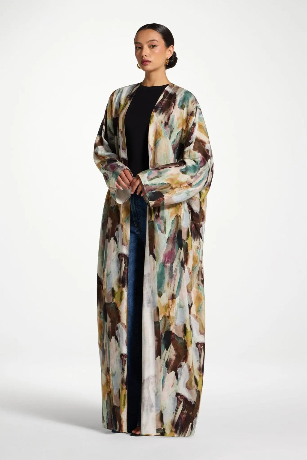 Woman wearing a long, abstract-patterned coat on a white background