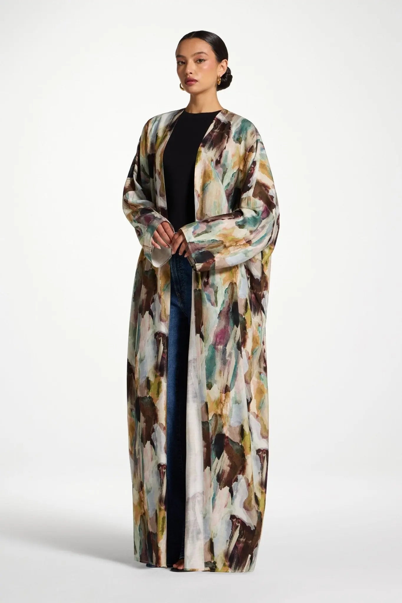 Woman wearing a long, abstract-patterned coat on a white background