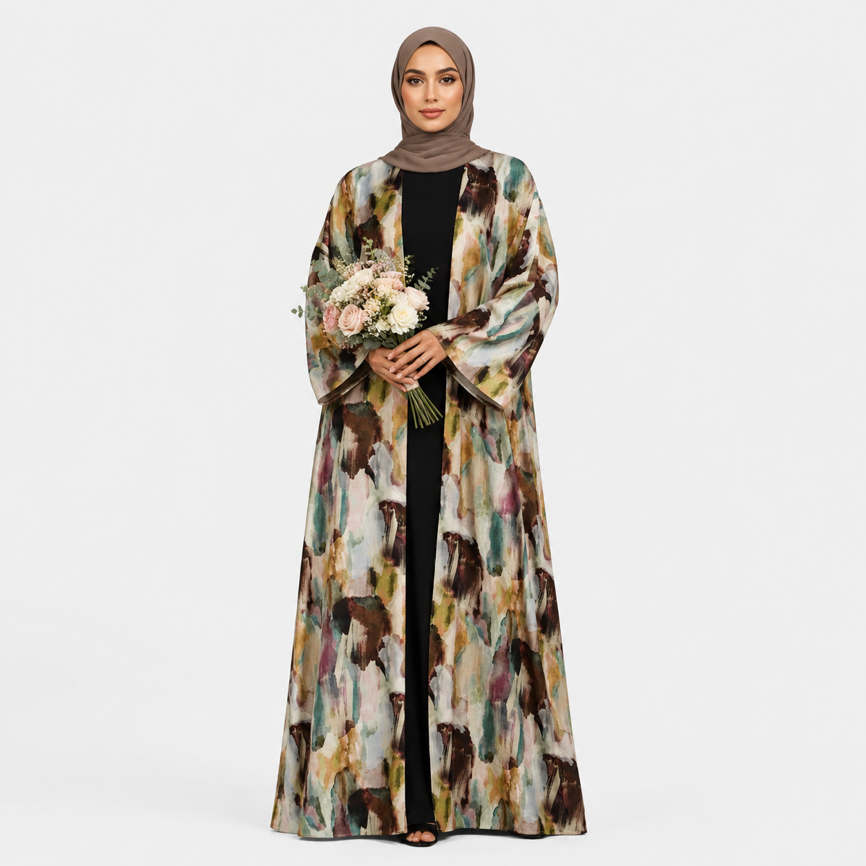 Woman wearing a long, patterned coat holding flowers on a white background