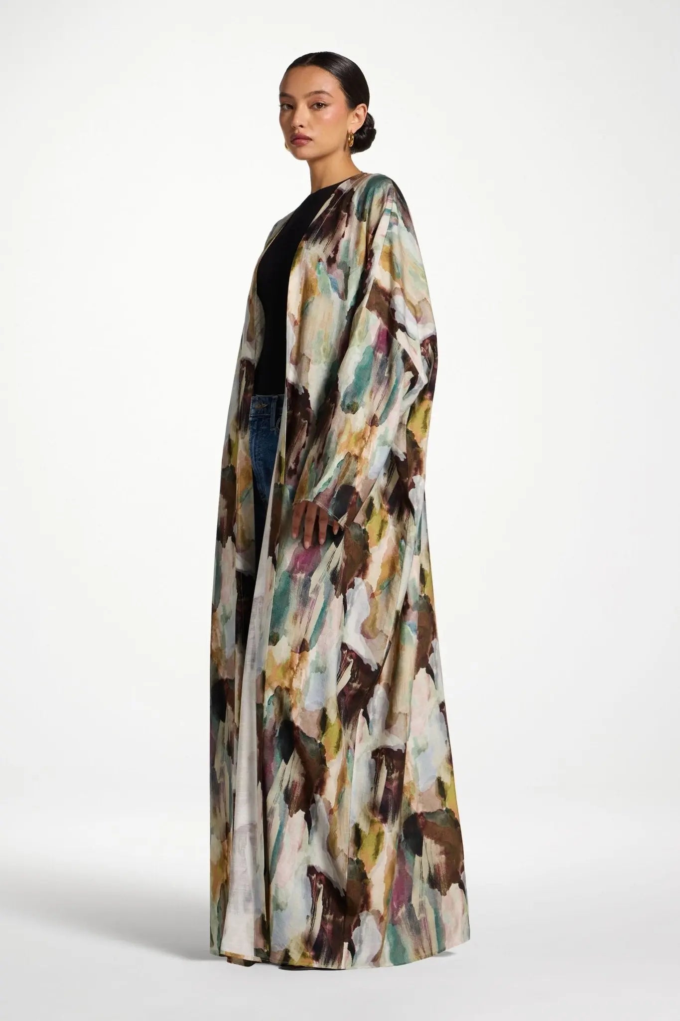 Woman wearing a long, patterned coat on a white background