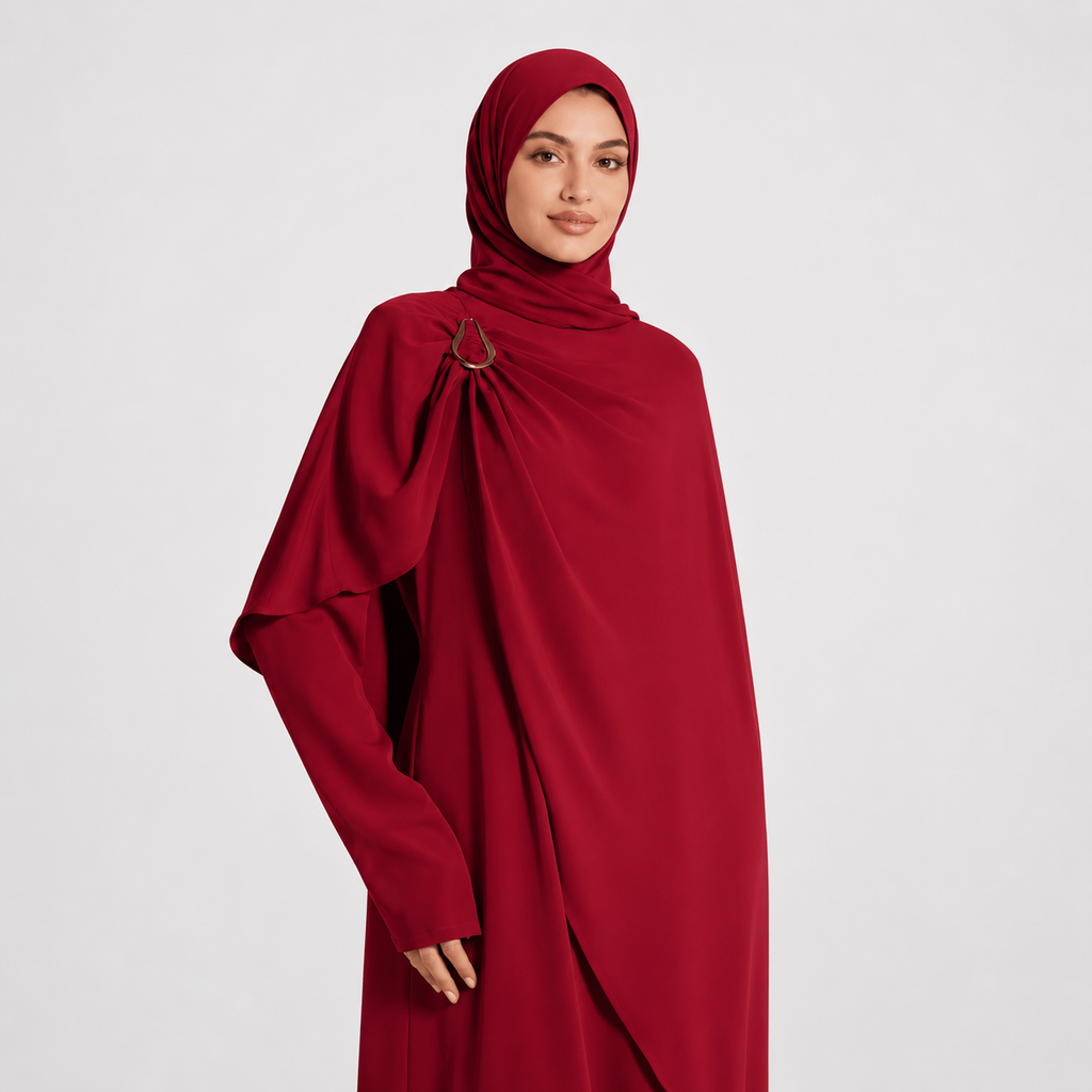 Woman wearing a red abaya on a light gray background