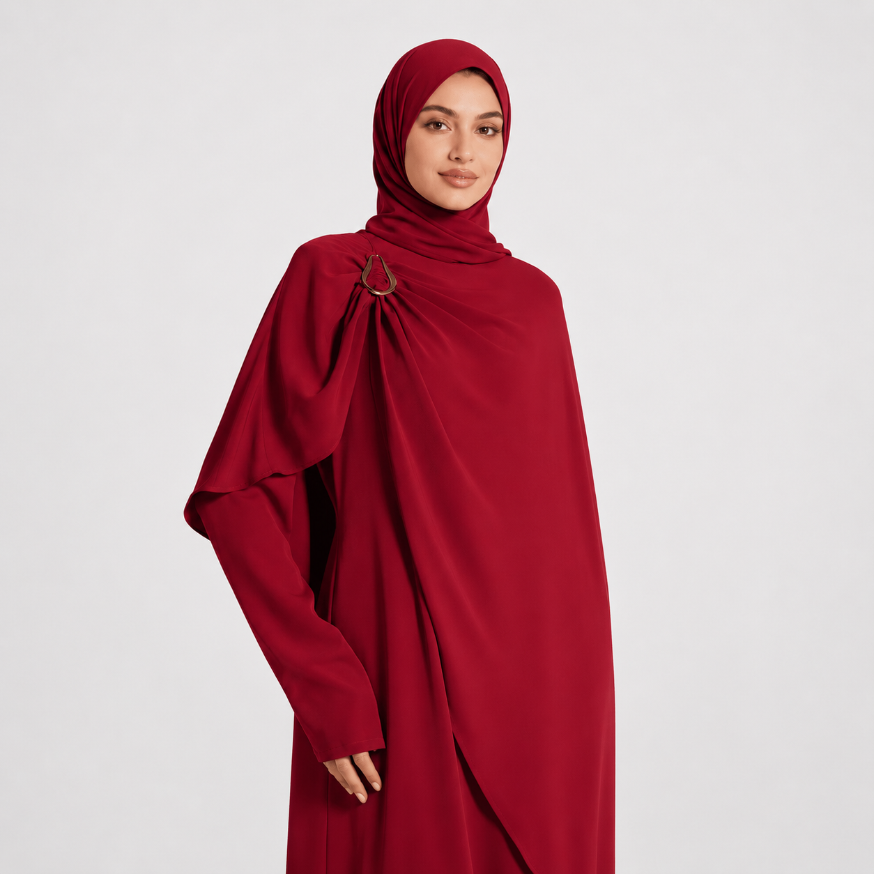 Woman wearing a red abaya on a light gray background