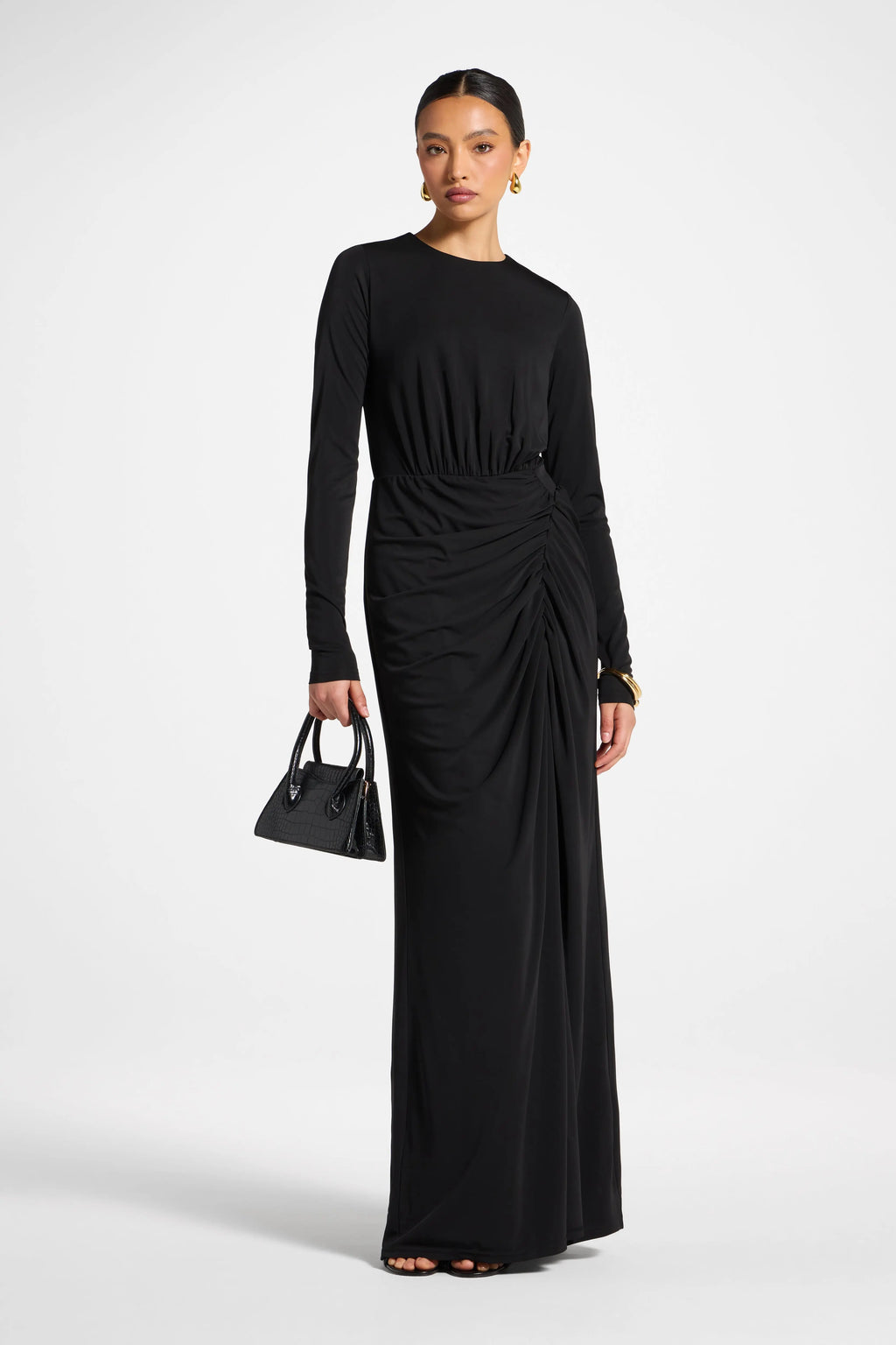 Woman wearing a black dress with a draped effect on a white background