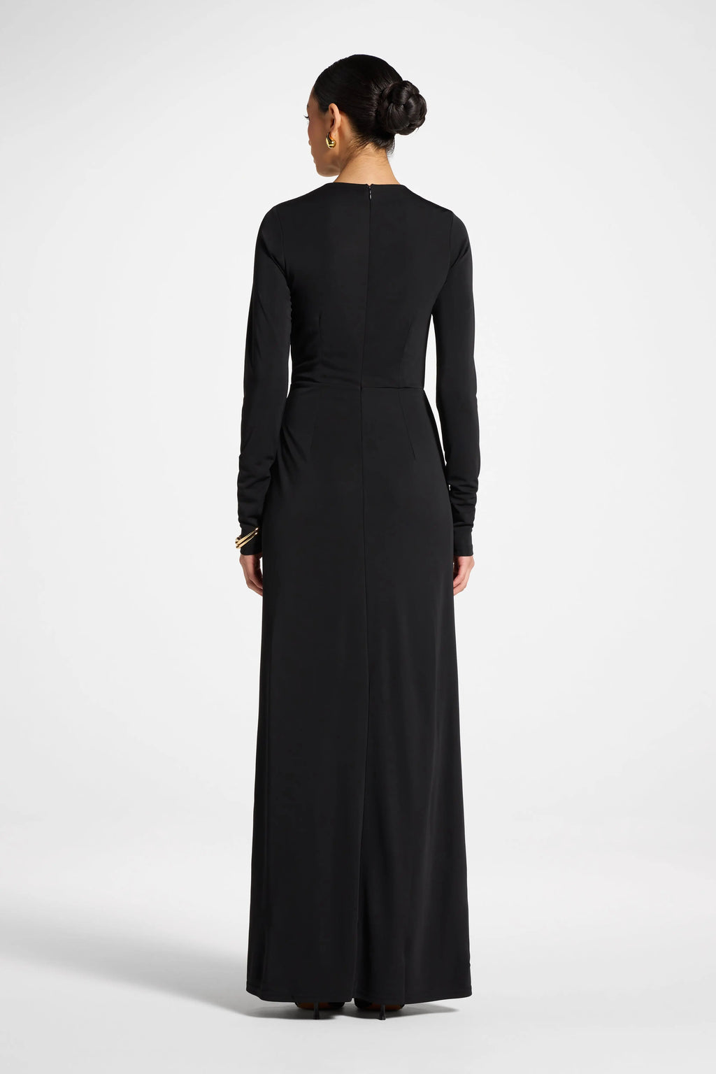Woman wearing a black long-sleeve dress on a white background