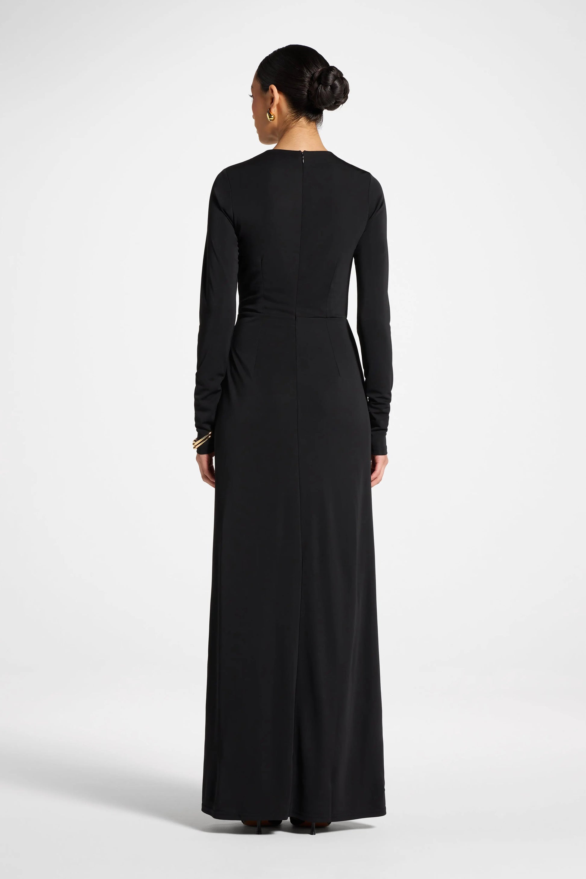 Woman wearing a black long-sleeve dress on a white background