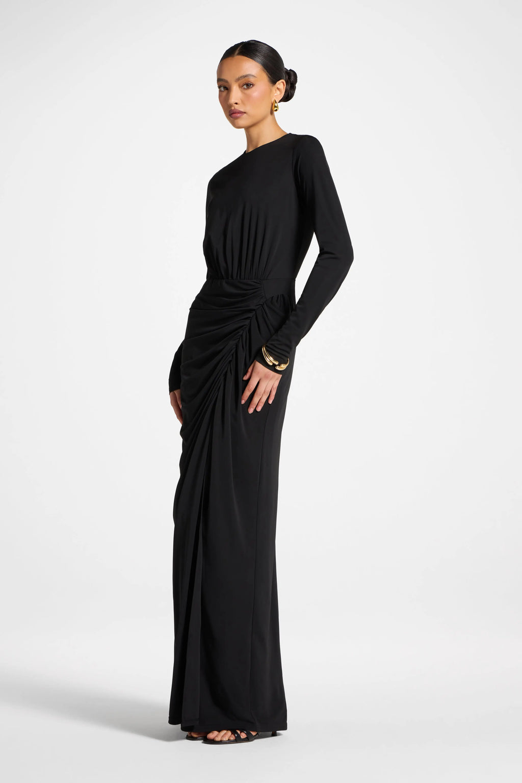 Woman wearing a black long-sleeve gown on a white background