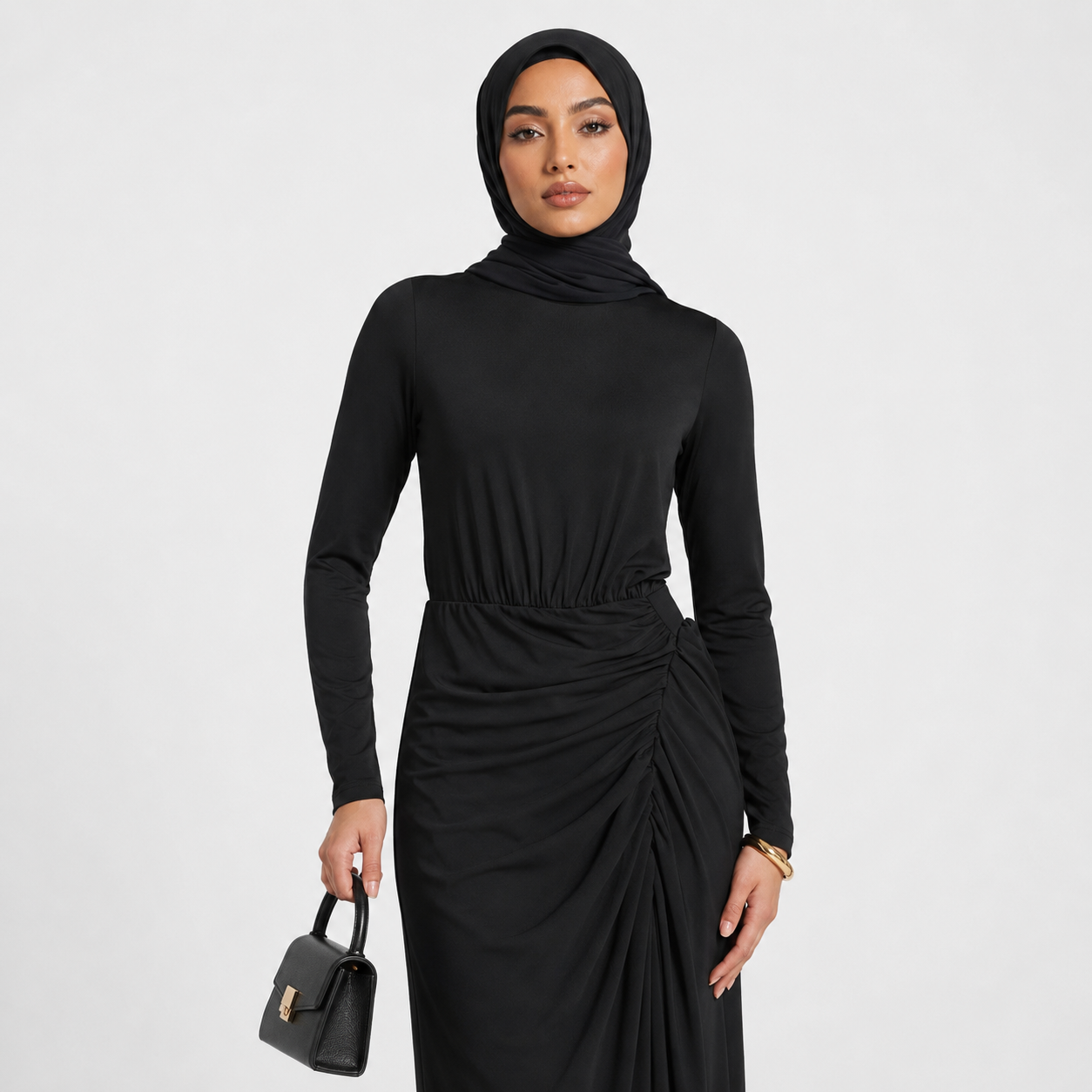 Woman wearing a black long-sleeve dress with a hood against a white background
