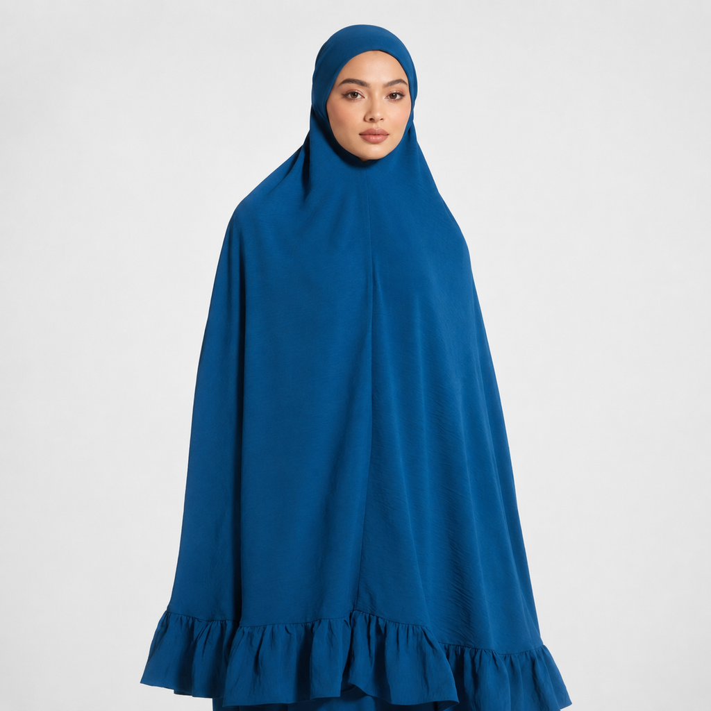 Woman wearing a blue hijab with ruffled bottom edge on a white background