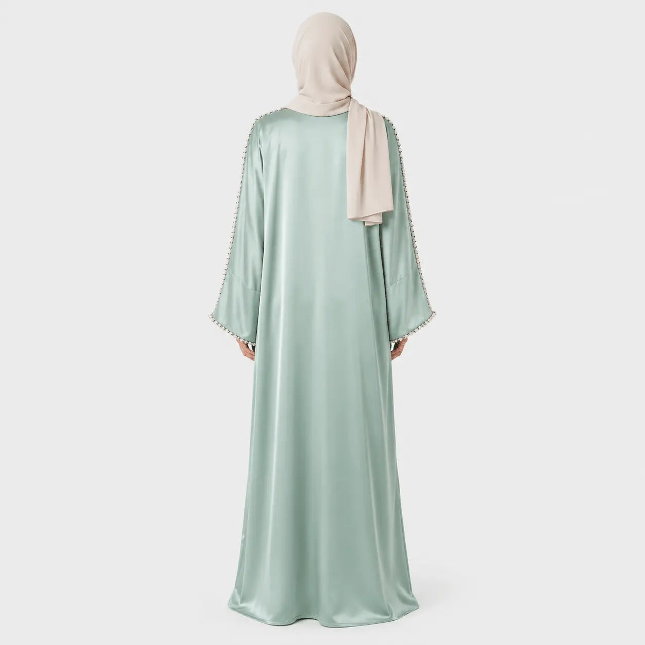 Mint green abaya with beige hijab on a white background