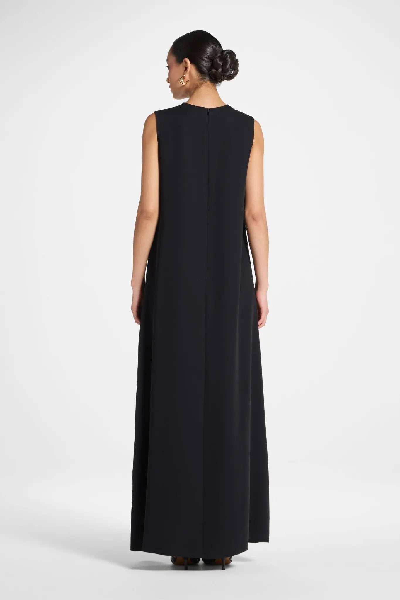 Woman wearing a black sleeveless dress on a white background