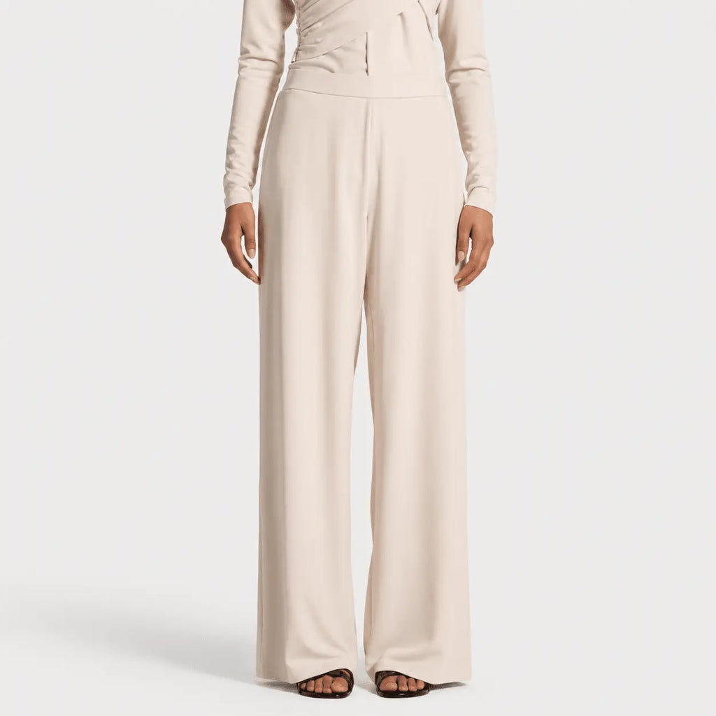 Beige jumpsuit worn by a model on a white background