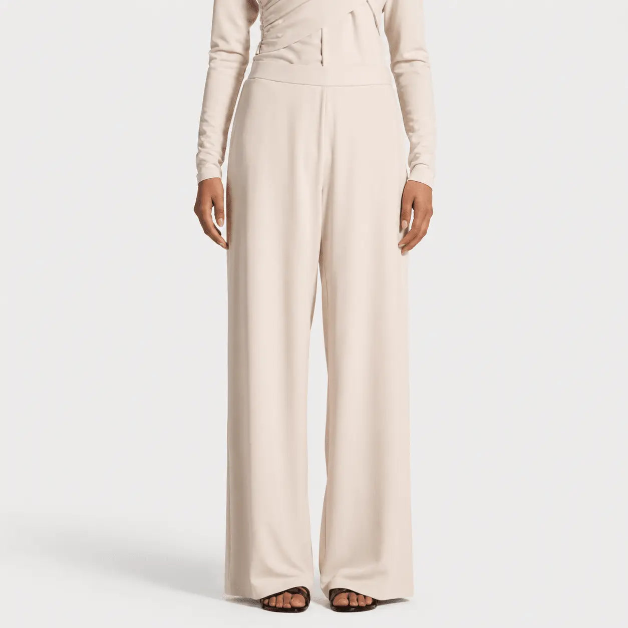 Beige jumpsuit worn by a model on a white background