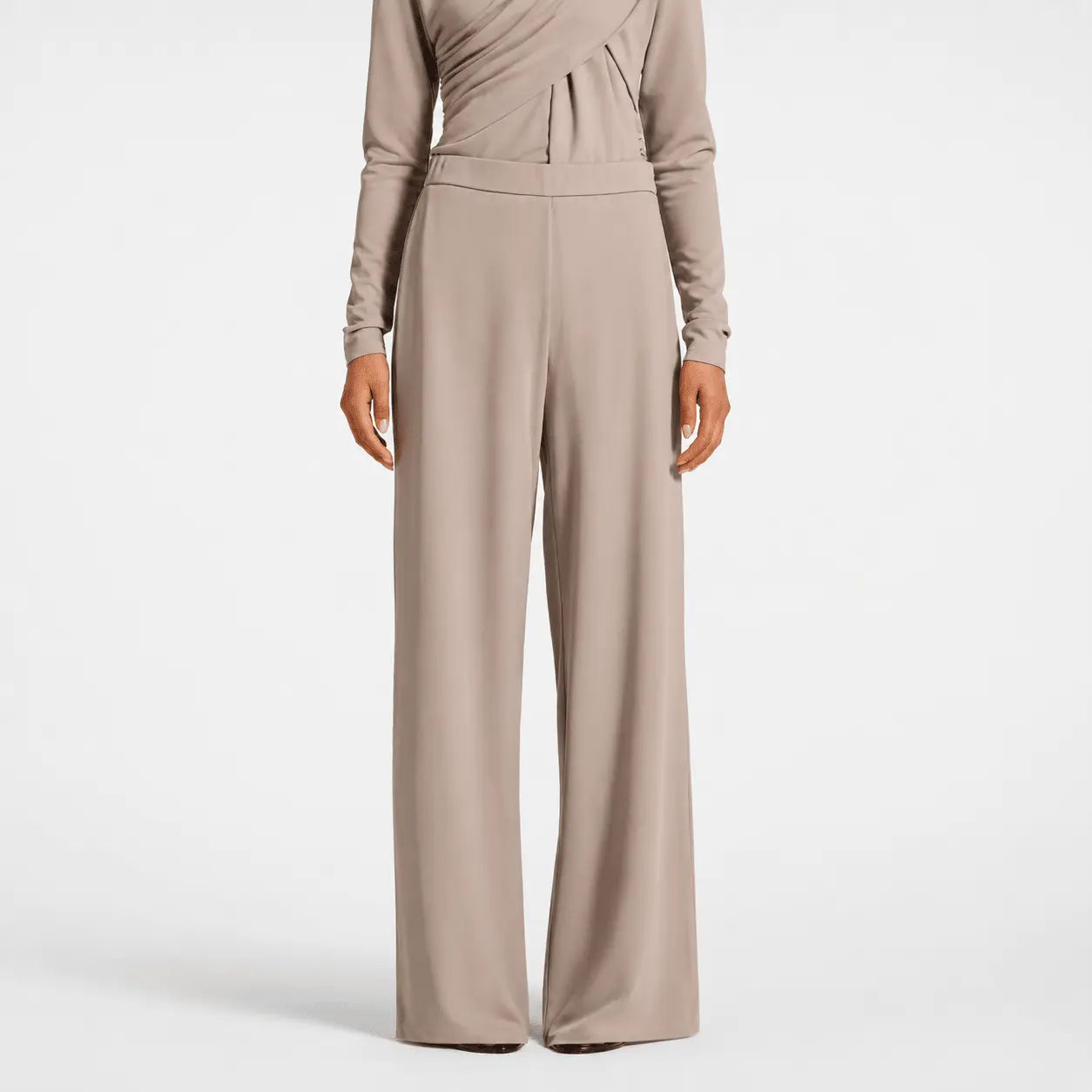 Beige jumpsuit worn by a person on a white background