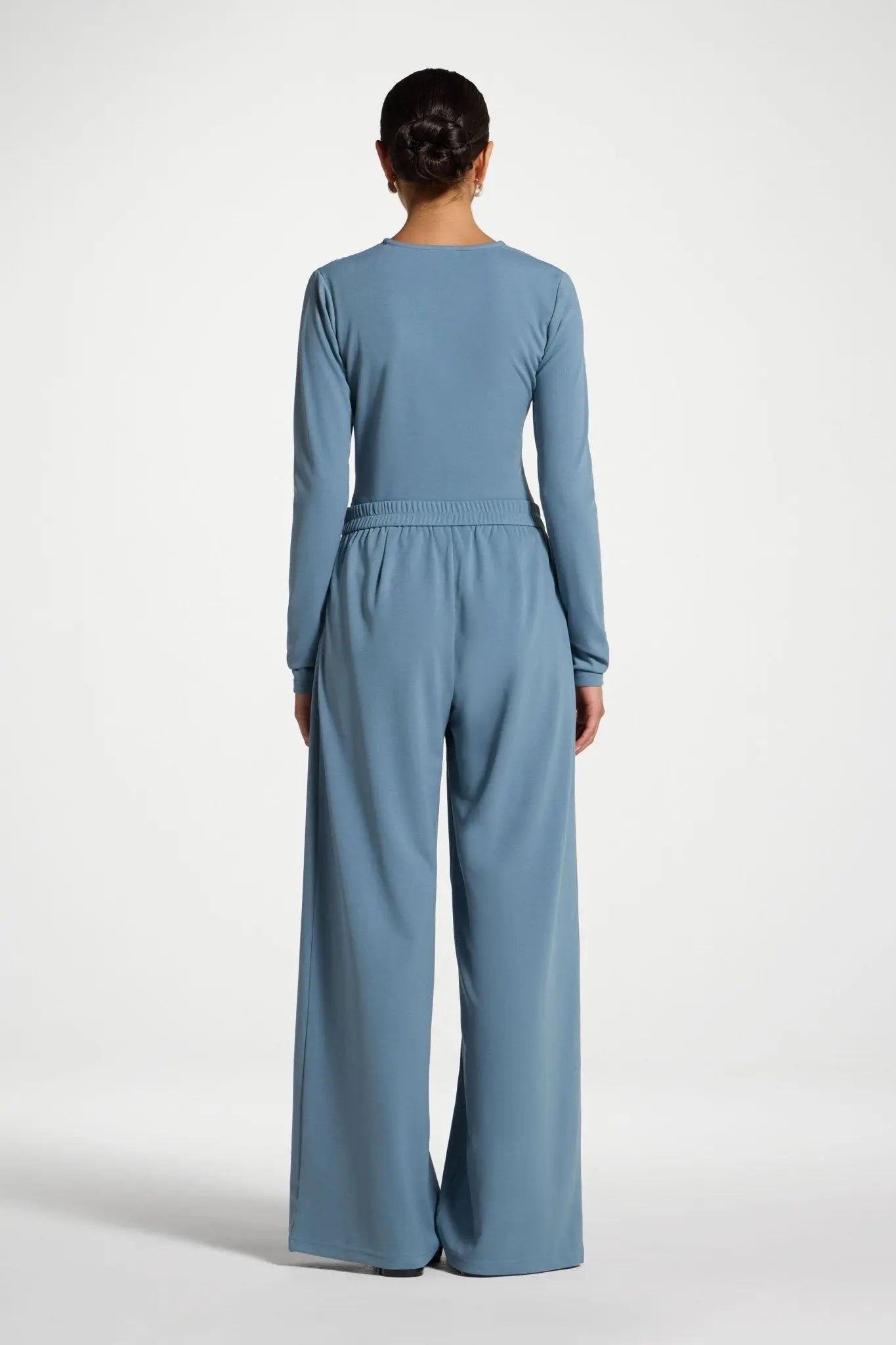 Person wearing a blue jumpsuit on a white background