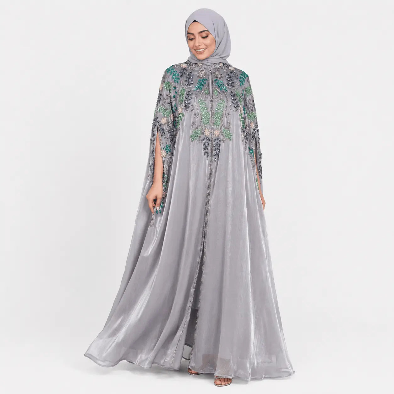 Woman wearing a gray embroidered dress on a white background