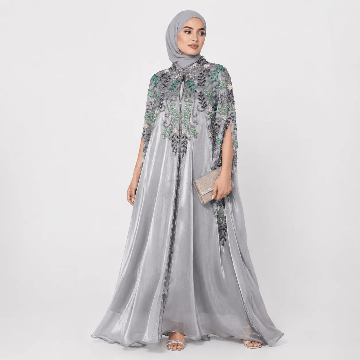 Woman wearing a gray embroidered dress on a white background