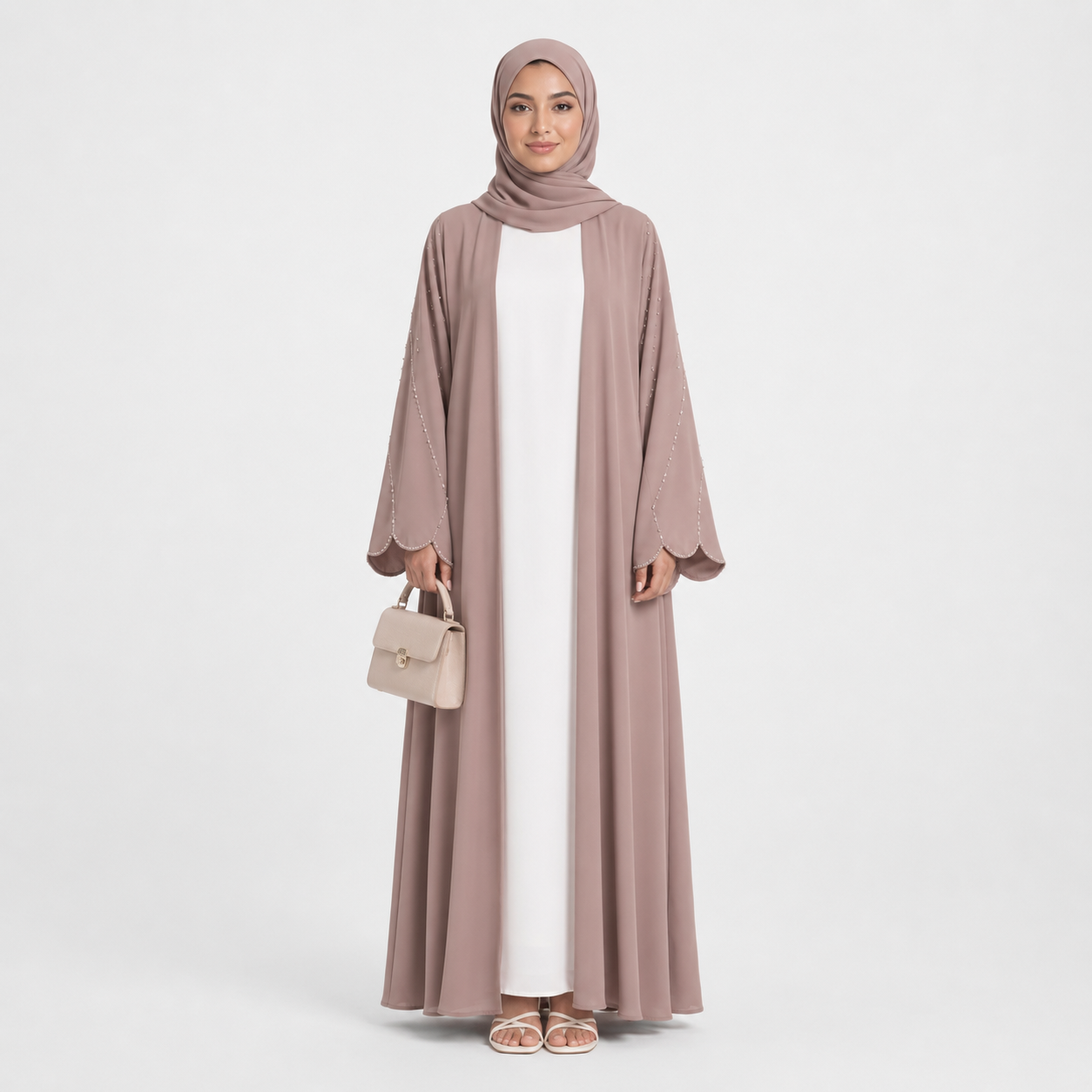 Woman wearing a long, light brown abaya with a matching hijab on a white background
