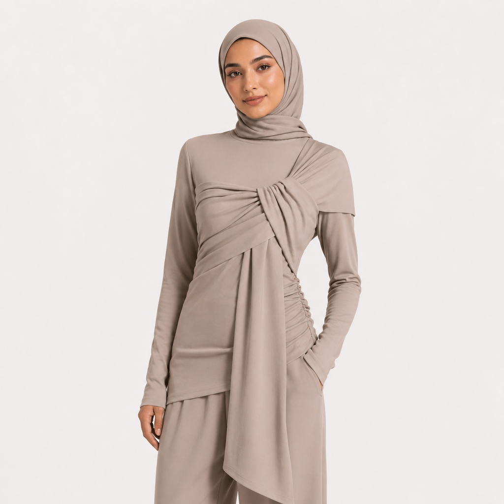 Woman wearing a beige long-sleeve top and hijab on a white background