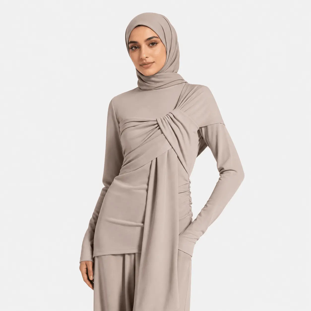 Woman wearing a beige hijab and dress on a white background