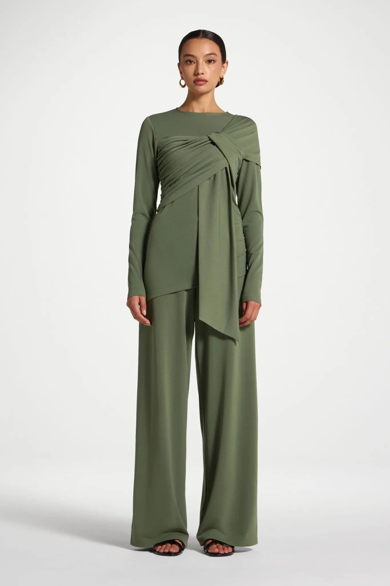 Woman wearing a green outfit on a white background