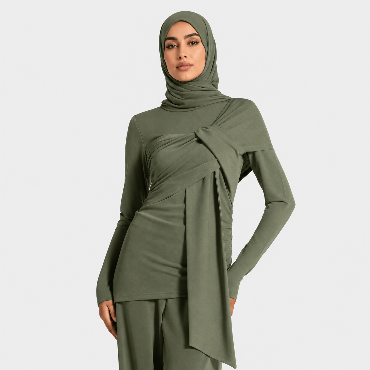 Woman wearing a green outfit with a hijab on a white background