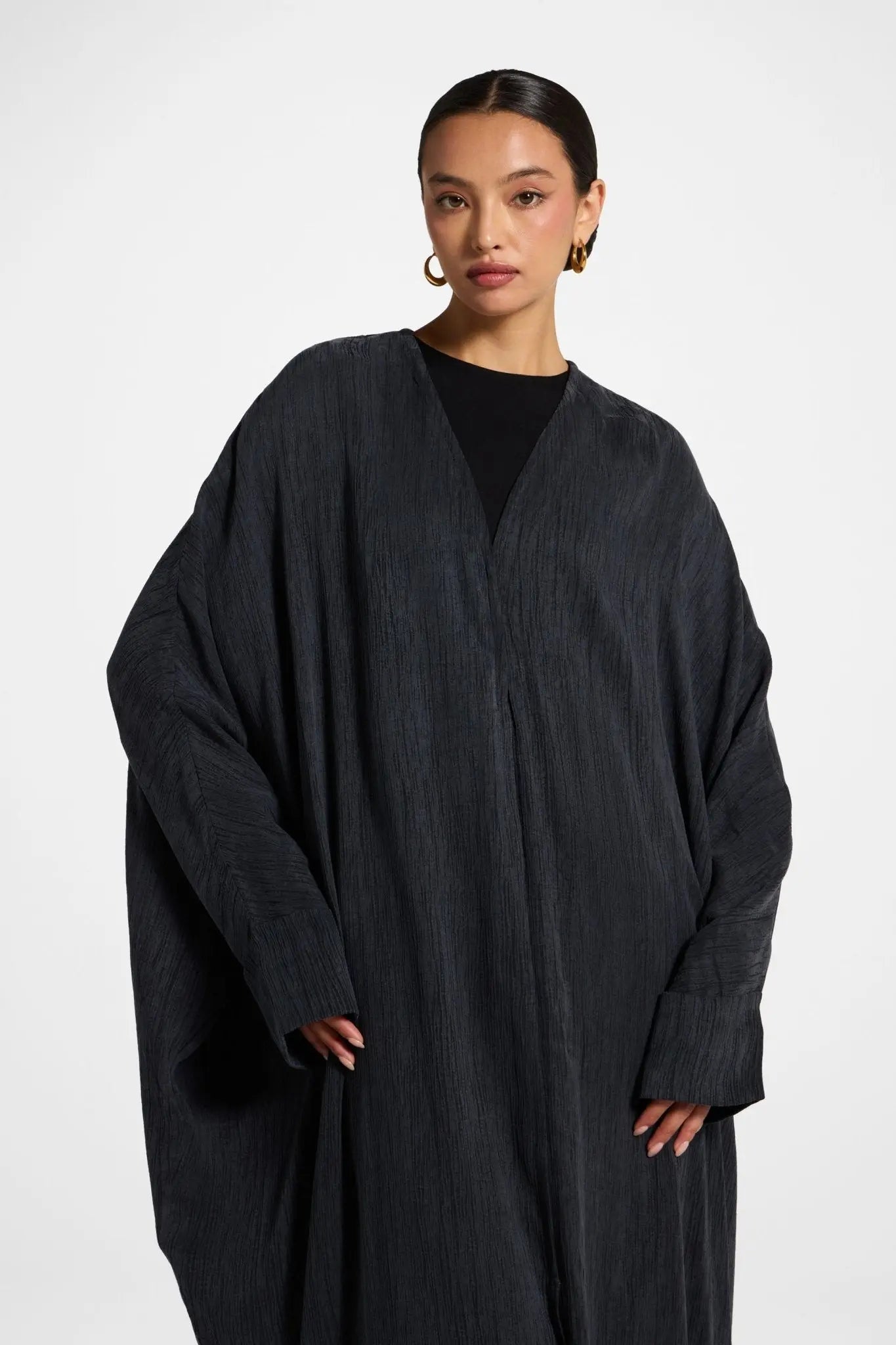 Woman wearing a black robe against a white background