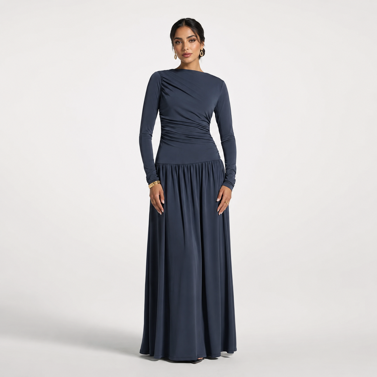 Woman wearing a long navy dress on a light gray background