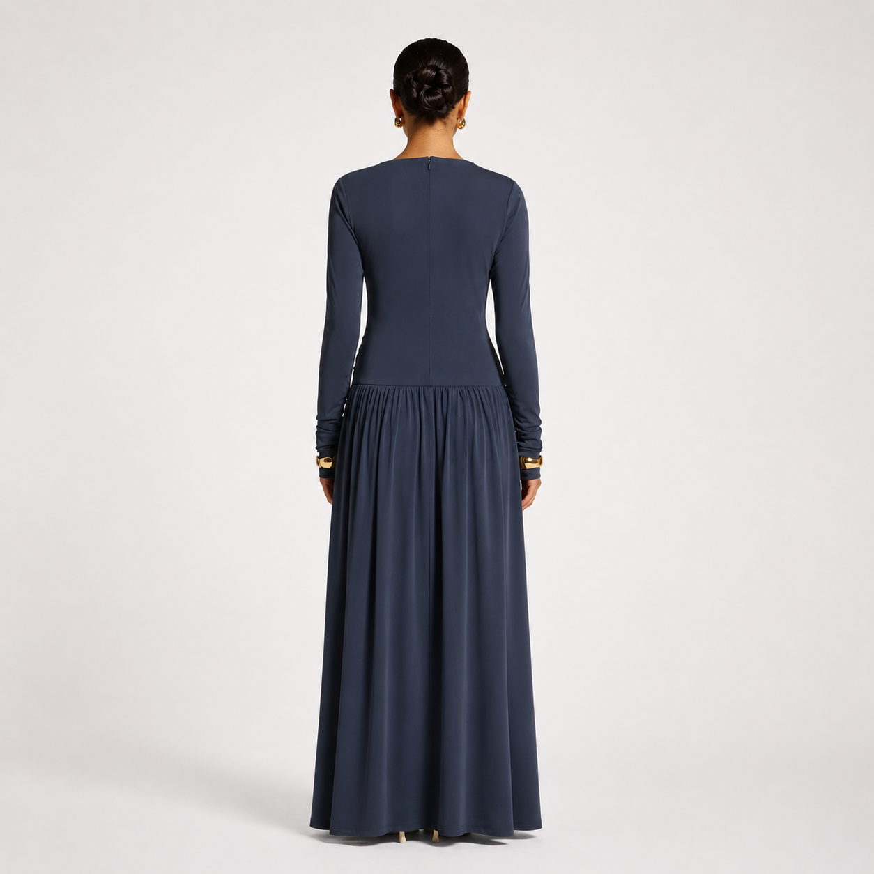 Woman wearing a long dark blue dress on a white background