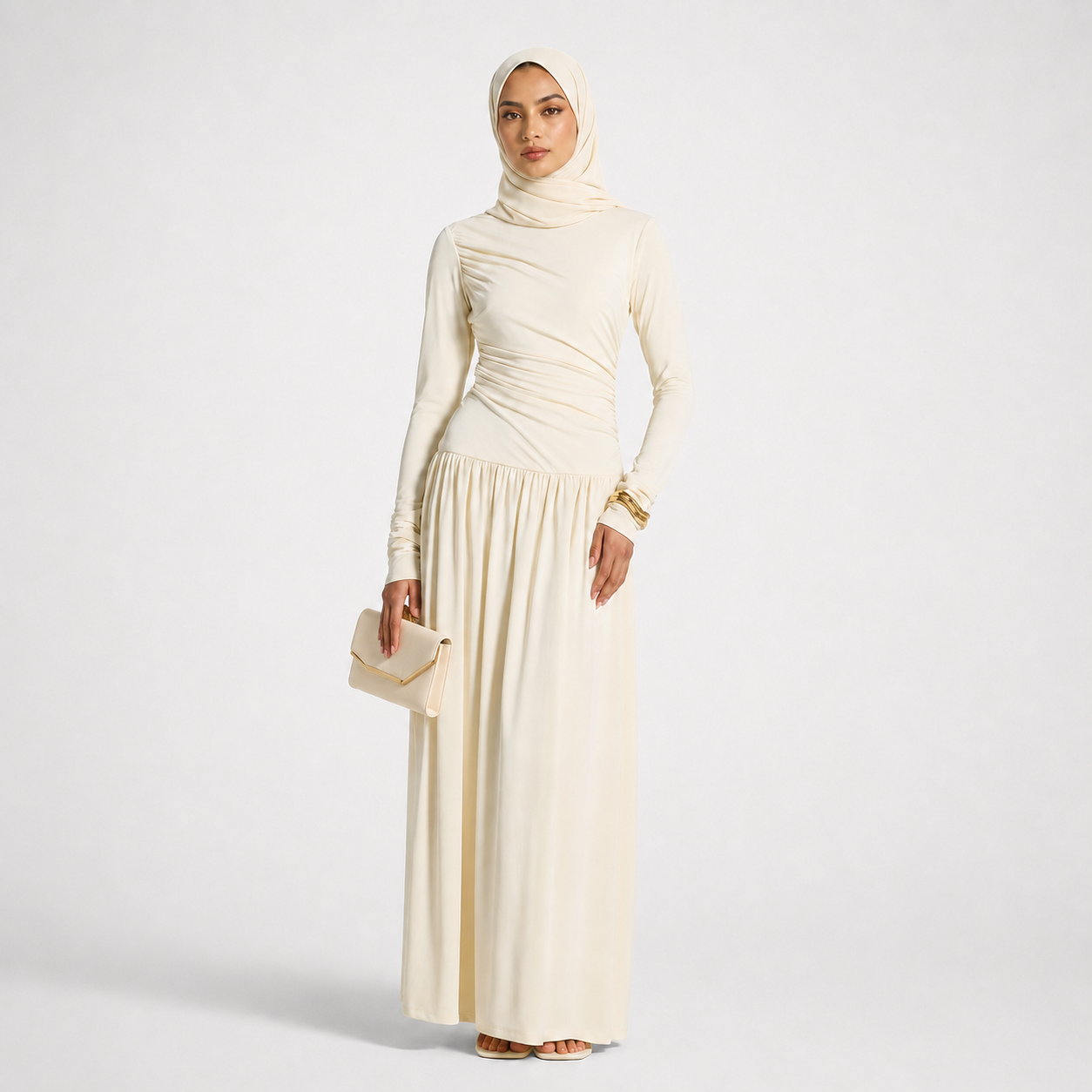 Woman wearing a long cream dress and hijab on a white background