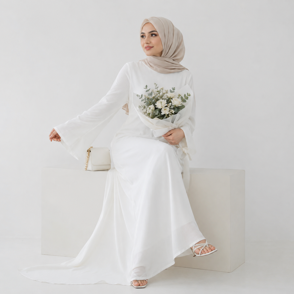 White modest abaya dress styled with beige hijab, floral bouquet, and cream handbag on a clean studio background
