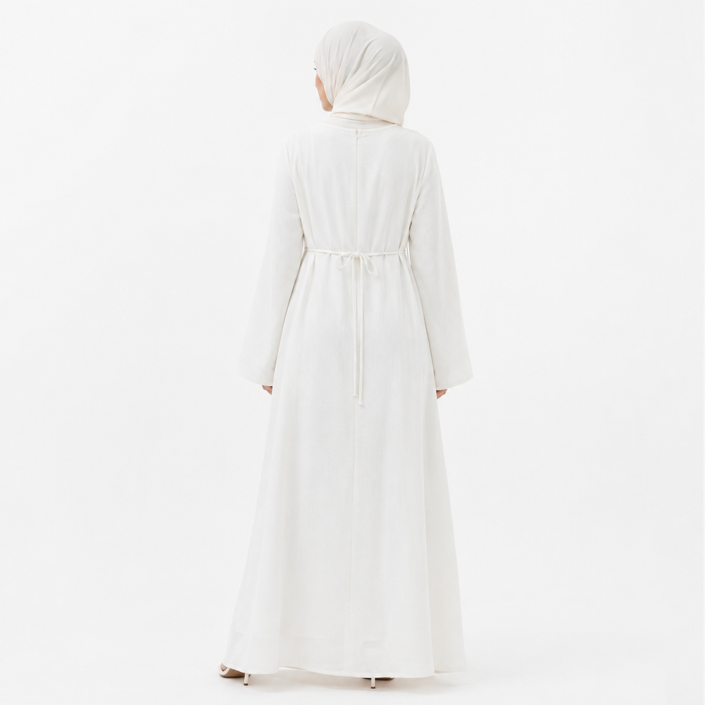 White modest abaya dress styled with beige hijab, floral bouquet, and cream handbag on a clean studio background
