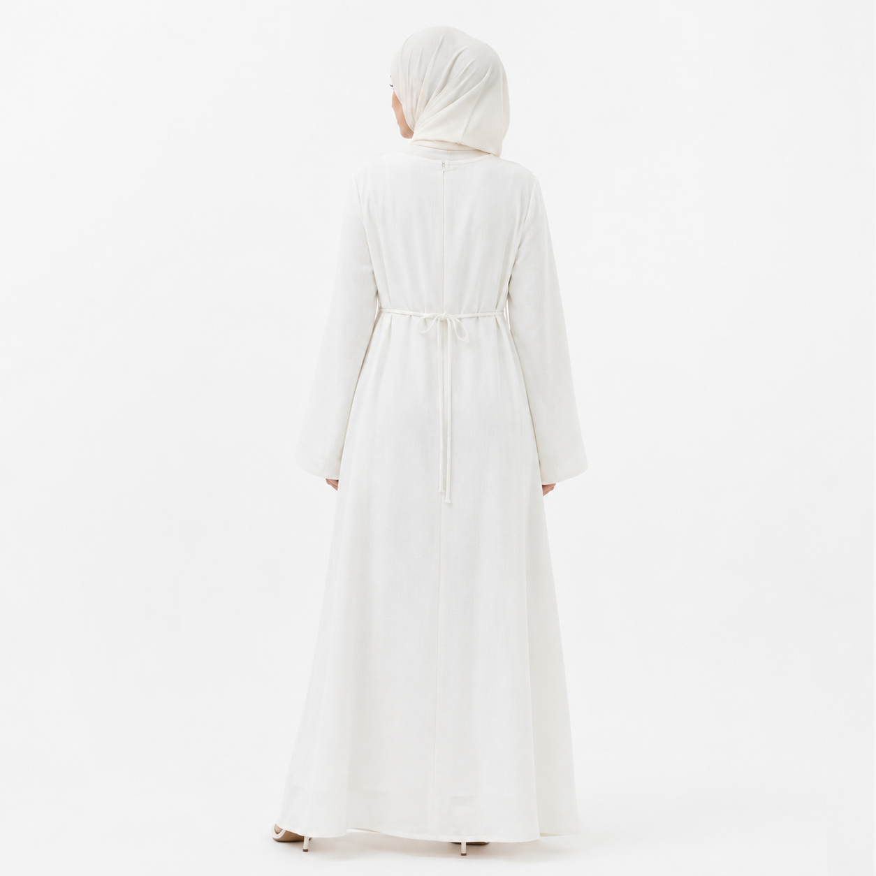 White modest abaya dress styled with beige hijab, floral bouquet, and cream handbag on a clean studio background
