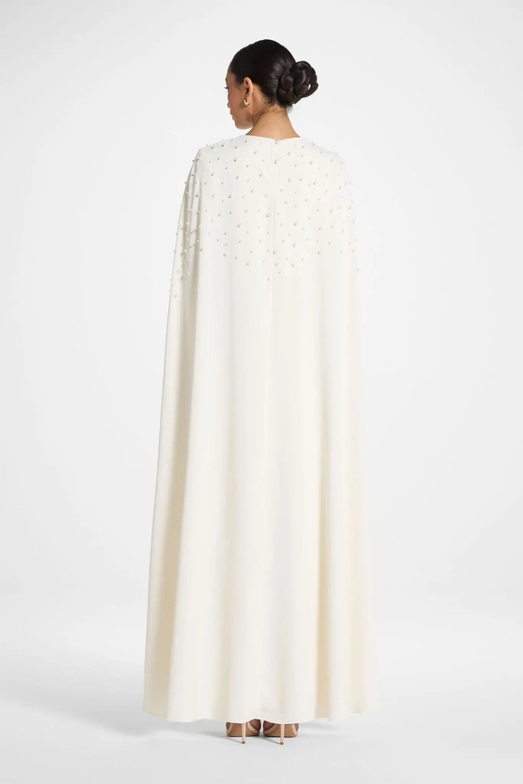 Person wearing a white cape on a white background