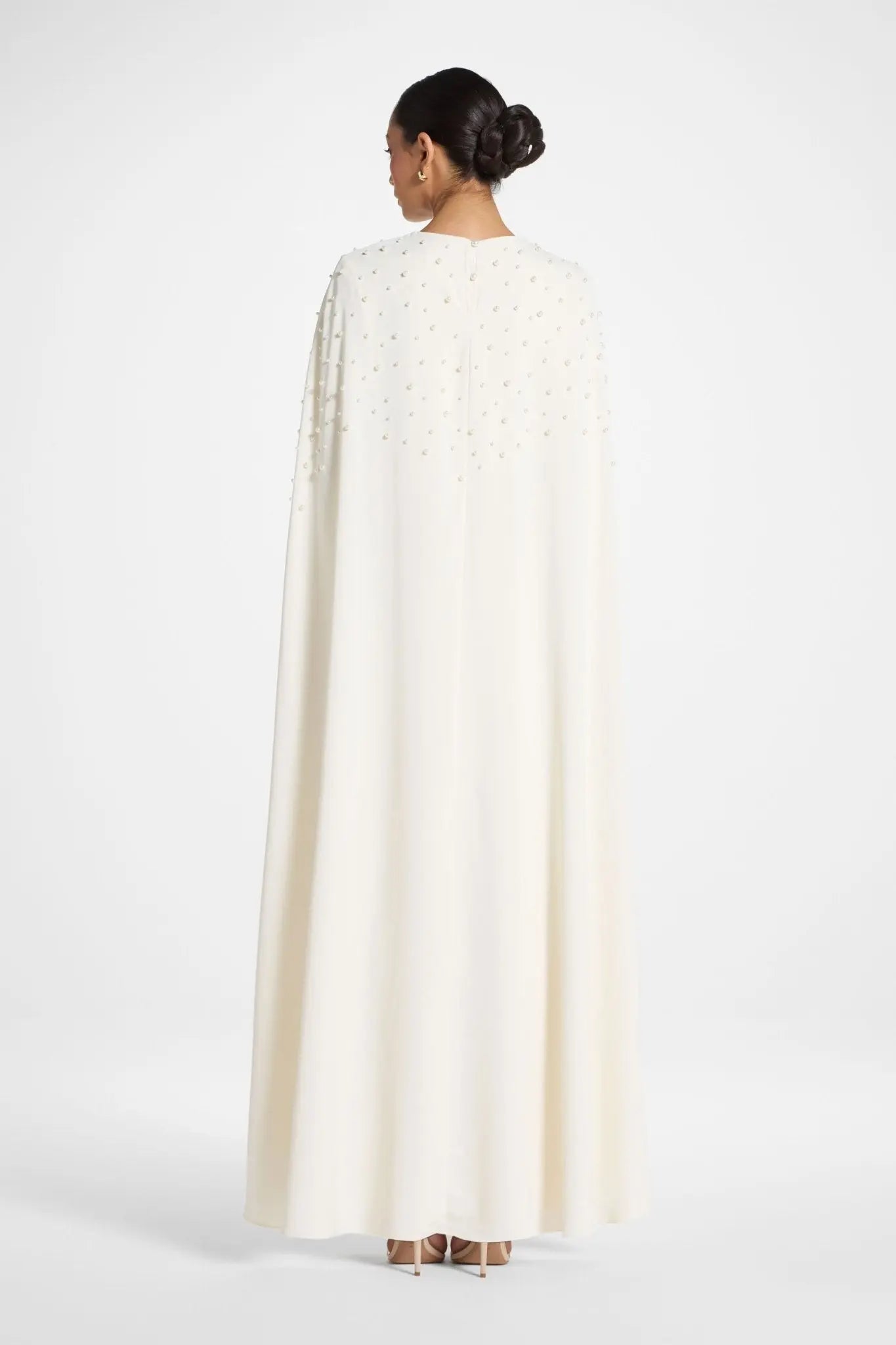 Person wearing a white cape on a white background