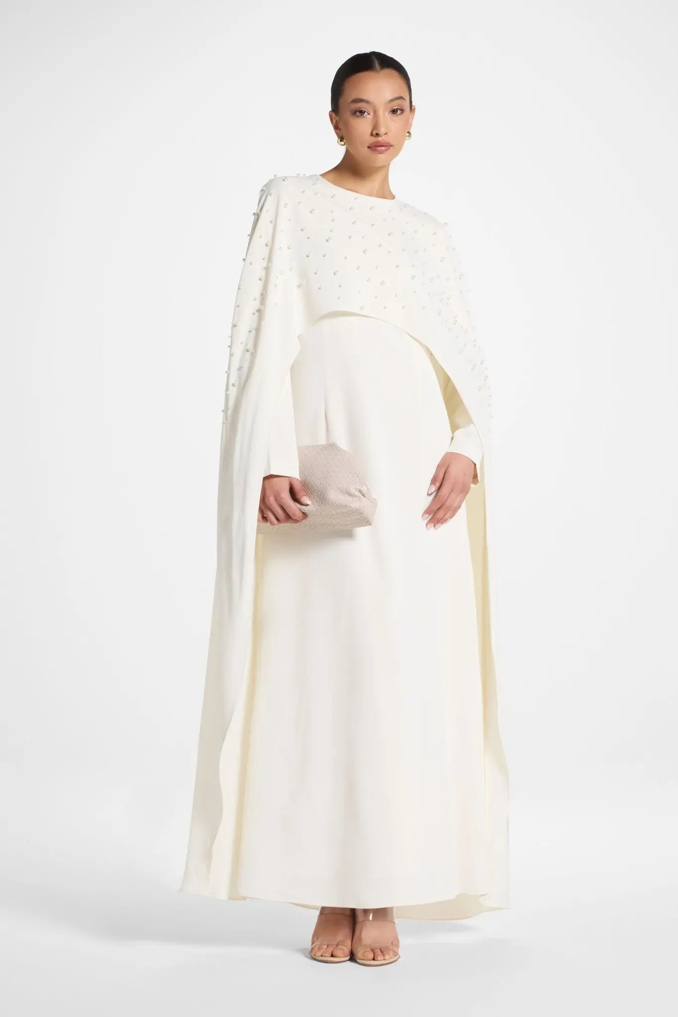Woman wearing a white dress with a cape on a white background
