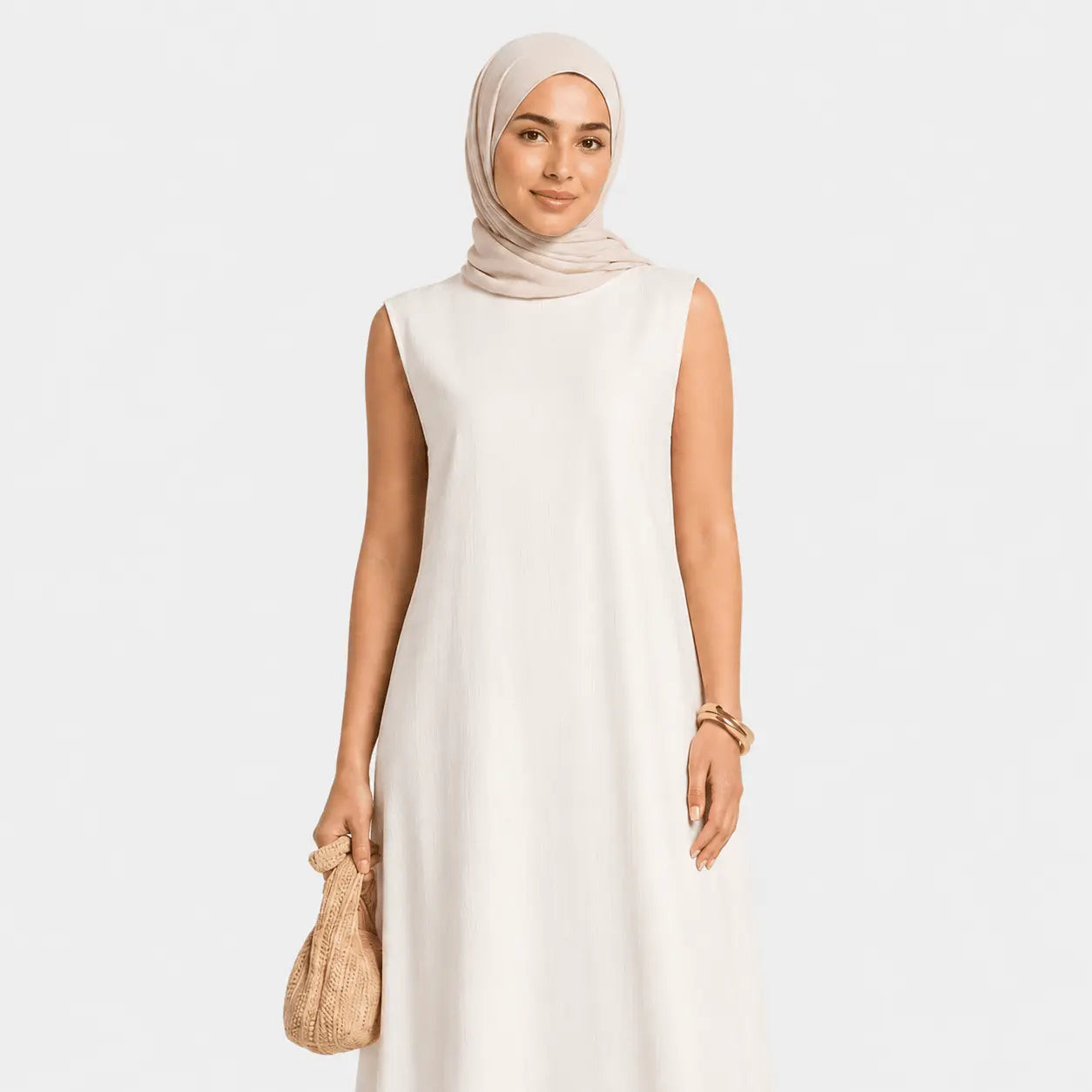 Woman wearing a beige sleeveless dress and hijab on a white background