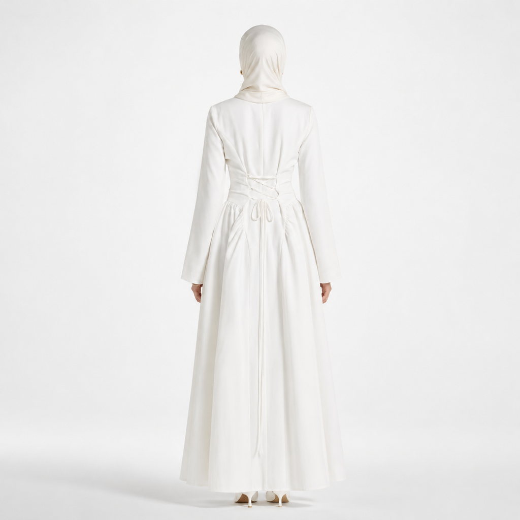 Person wearing a long white dress with a matching hijab on a white background