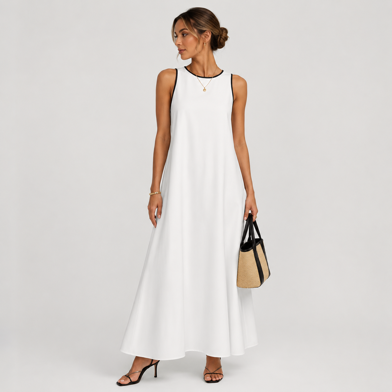 Woman wearing a white sleeveless dress holding a black and beige handbag on a plain background